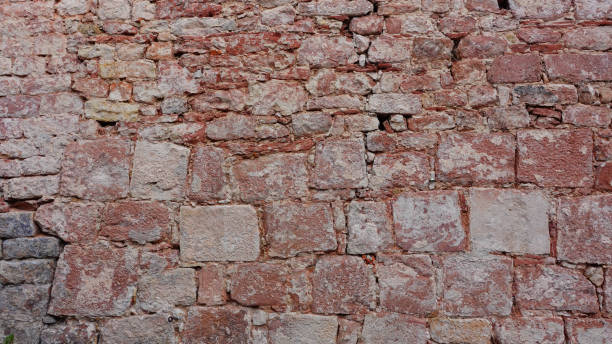 Rough Textured Stone Wall With Varying Hues Observed in Natural Light
