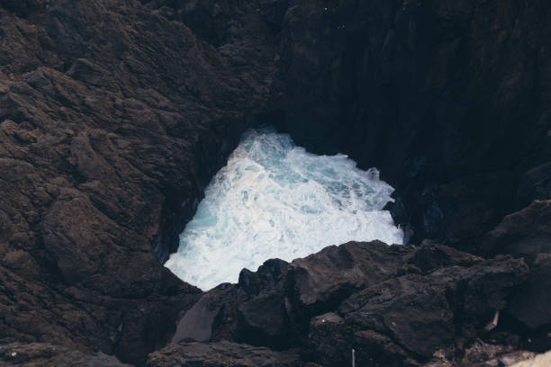 istock Wave Crashing into Rocky Crevice 2180800406