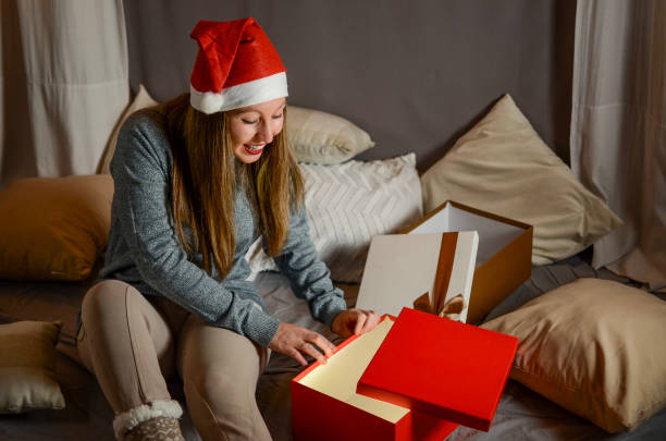 istock Woman opening her gift from Santa Claus 2180801294