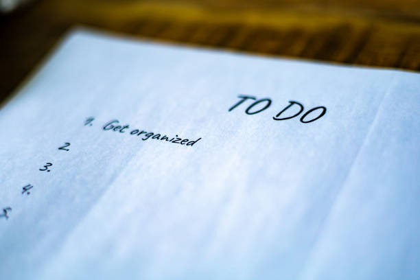 Cut or torn lined paper background with checklist isolated on black.