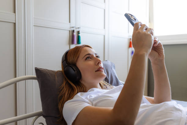 Woman relaxing in bed and using phone