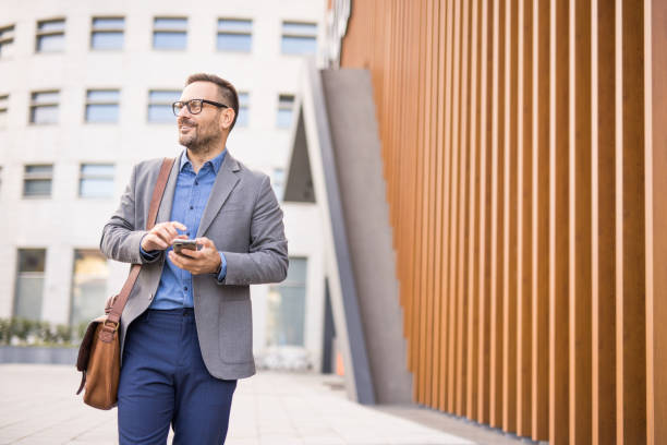 istock Good looking men use smartphone while going to work in the city. 2180805905
