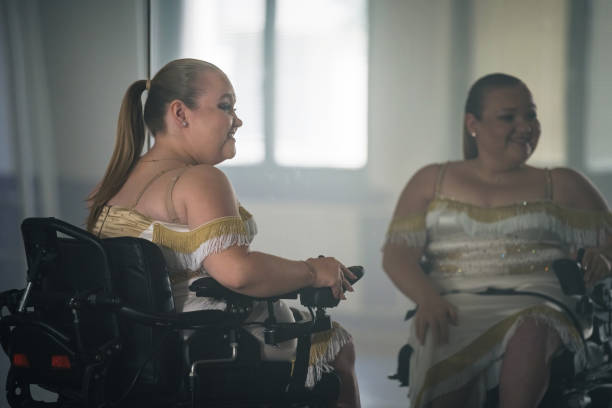 istock Woman, a wheelchair dancer checking her look in a mirror at a dance studio 2180810548