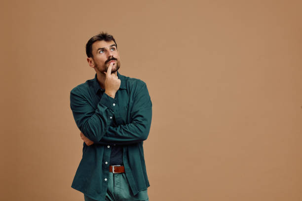 Portrait of thoughtful man looking up. Studio shot of pensive man looking up while thinking of something. Copy space. contemplation stock pictures, royalty-free photos & images