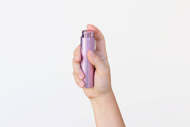 istock Young woman's hand holding lilac atomiser for perfume isolated on a white background 2180813442