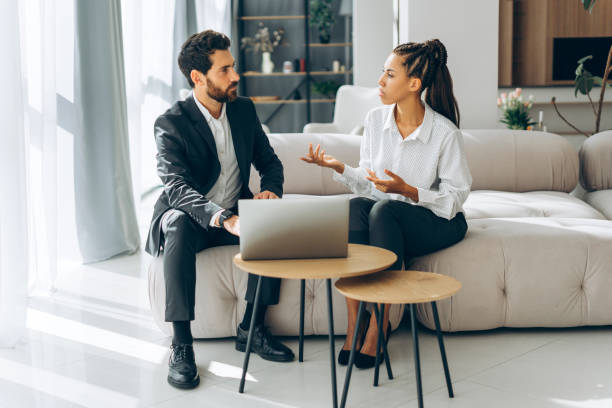 istock Businesspeople talking, discussing, using laptop, planning project sitting on comfortable sofa 2180815255