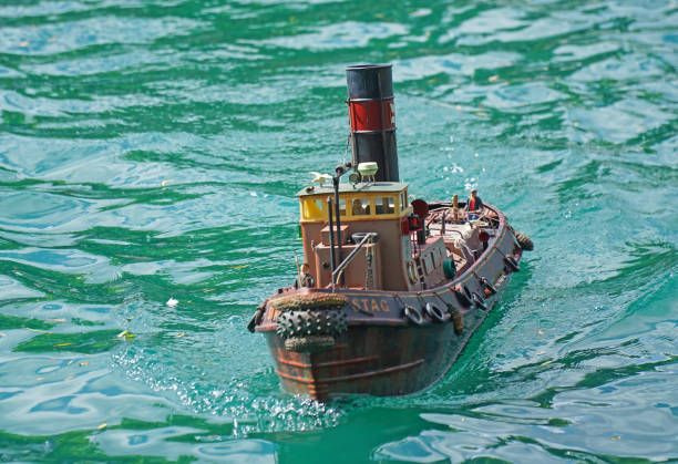 Kettering, Northamptonshire, England - May  25, 2024:  Model tug boat on boat pond