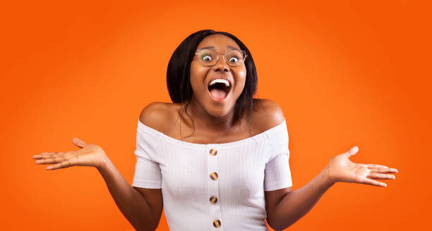 istock Excited Afro Girl Shouting Gesturing With Hands Standing, Orange Background 2180816255