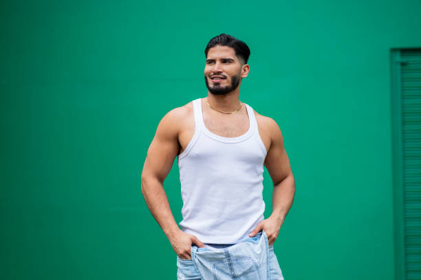 man with casual clothes on a summer day, with casual clothes and a green wall in the background