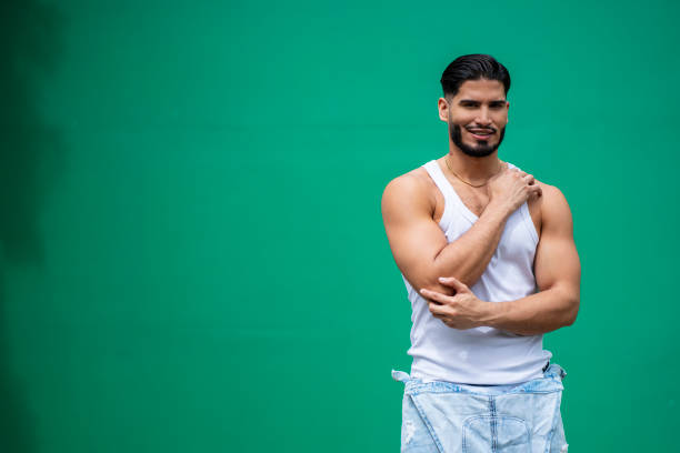 Portrait of a young gay man dancing on a blue background