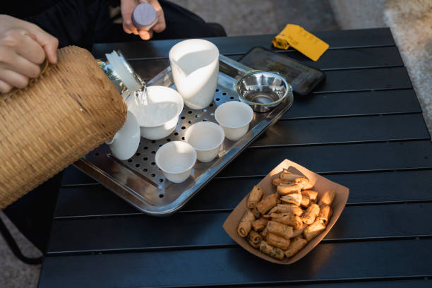 Outdoor leisure time, woman making tea with snacks next to her, lifestyle concept