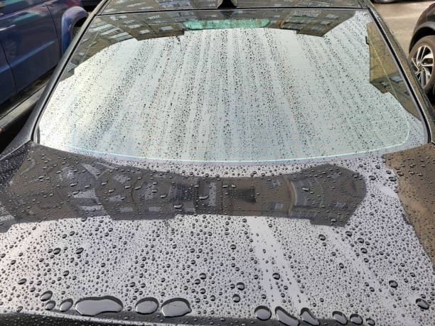 istock Raindrops and reflections on a dark car in rainy weather. 2180823154