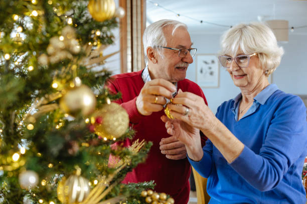 istock Senior couple decorating Christmas tree at home together 2180825286