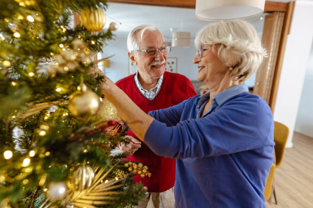 istock Senior couple decorating Christmas tree at home together 2180826300