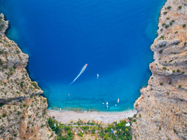 istock Aerial View of Stunning Beach Between Cliffs with Boats 2180828428