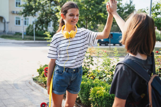 istock Kids high-five each other in a lush green park 2180831419