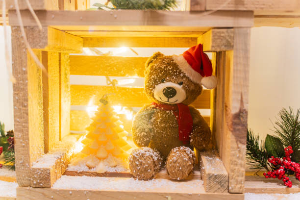 A teddy bear in a Christmas hat on display Christmas toys
