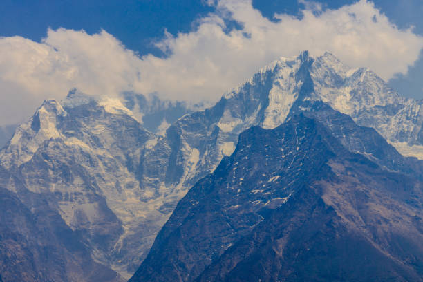 Snow-covered mountains rise dramatically against a vibrant blue sky in the Annapurna region. This breathtaking view captures the essence of trekking in Nepal's majestic landscape