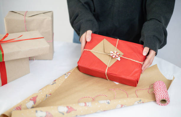 istock female hands pack Christmas presents 2180842132