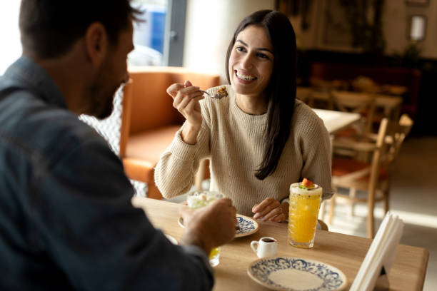 istock Young and beautiful couple enjoying time together in a cafe while eating chocolate cake 2180849717