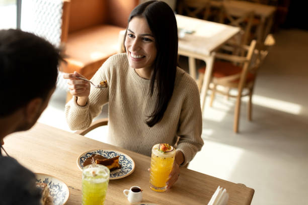 istock Young and beautiful couple enjoying time together in a cafe while eating chocolate cake 2180849724