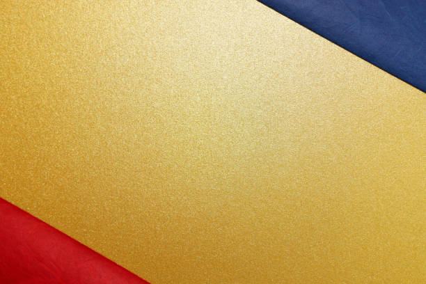istock gold, red and blue paper background 2180858503