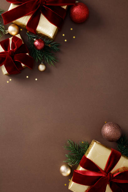 istock Elegant Christmas ornaments and gift boxes on chic brown background. Flat lay, top view, vertical 2180859377