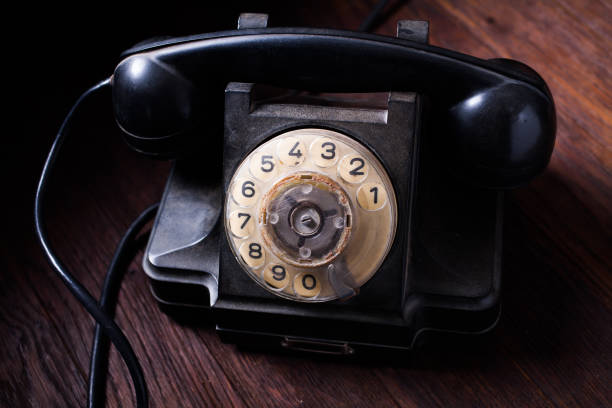 istock Noir concept - antique retro rotary phone on wooden table 2180859873