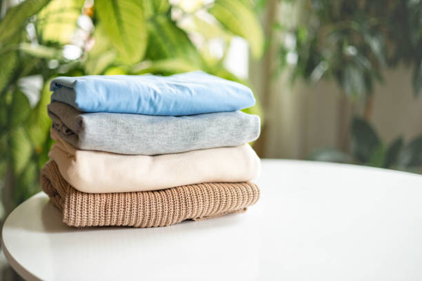 istock Stack of neutral knitted clothes made of natural materials lies on table. 2180860854