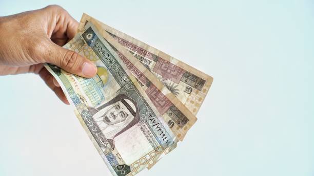 istock hand with holding Saudi Riyal notes isolated on white background 2180861196