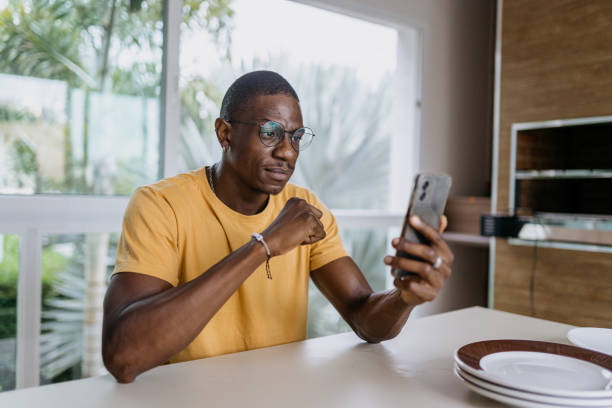 istock Serious man looking at smartphone at home 2180863150
