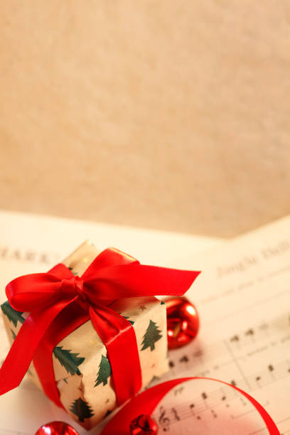 istock Small Present Resting On Christmas Sheet Music 2180869691