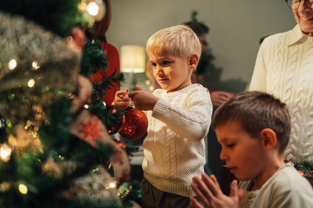 istock Happy family decorating christmas tree at home 2180892372