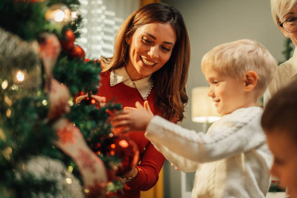 istock Happy family decorating christmas tree at home 2180892395