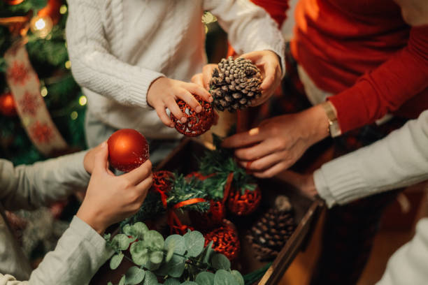 istock Family decorating for christmas holding up ornaments 2180892396