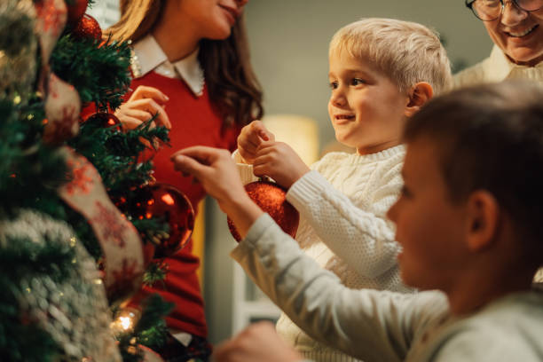 istock Happy family decorating christmas tree at home 2180892399