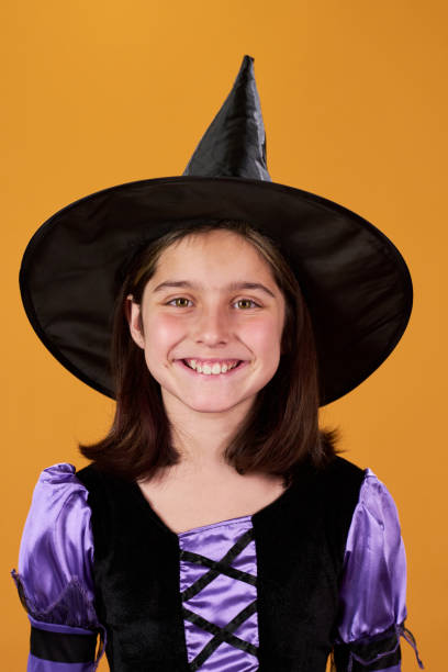 The four-years-old girl is sitting on the sofa at home, and preparing for the Halloween party.