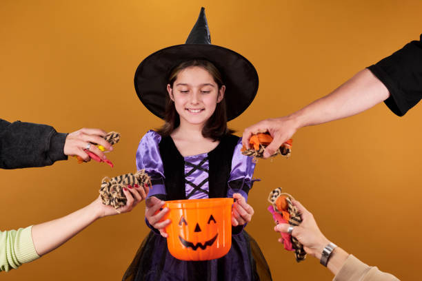 istock Hands putting candies into witch bucket 2180893384