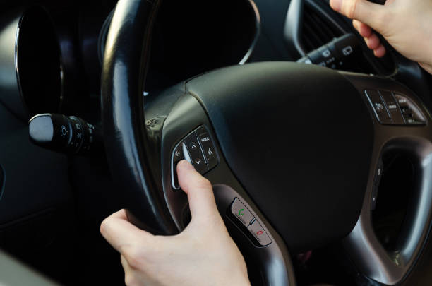 istock female hand, switches the volume using the buttons located on the steering wheel 2180893510