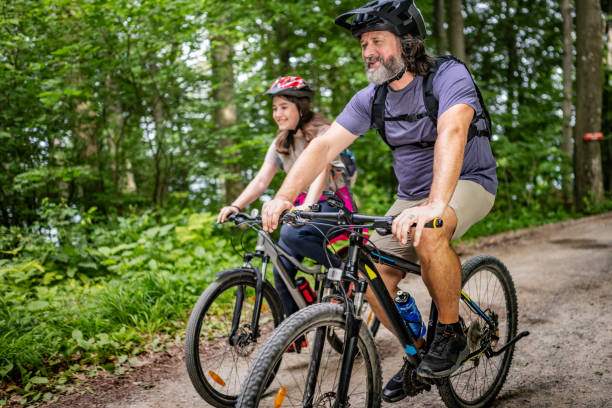 istock Caucasian Father-Daughter Duo Biking in Forest 2180896776