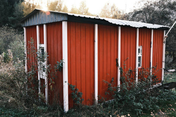 istock Red wooden utility shed with white trim in rural setting, rustic countryside architecture 2180908953