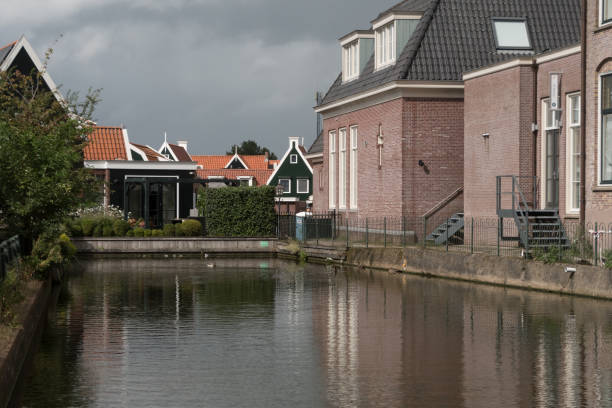 istock Quiet smooth waters in canal in old neighborhood in Volendam - 2 2180912578