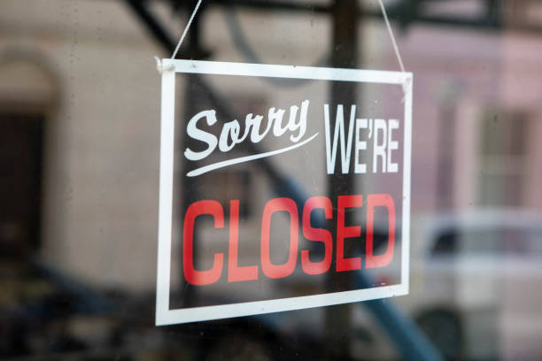 istock Closed sign in a shop door window 2180913593