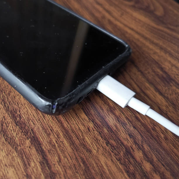istock The smartphone is charging on the table. A phone charger. Background, place for text. 2180913729