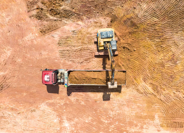 istock Excavator on earthmoving with grab crane unloads sand from freight car 2180914296