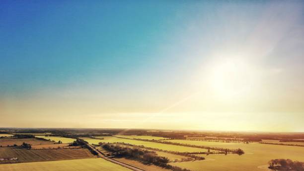 istock Aerial view of sunlit rural fields under a clear sky. 2180915240
