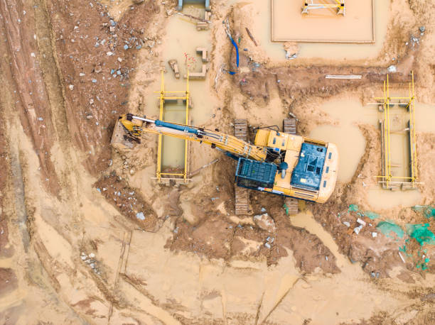 istock excavator on caterpillars in the foundation pit during the construction of the building foundation, digging. Aerial top view 2180916209