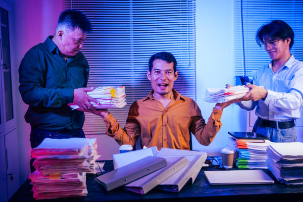 Three colleagues collaborate in a workplace while addressing a challenging situation, showcasing teamwork, diversity, and problem-solving in a professional office setting.