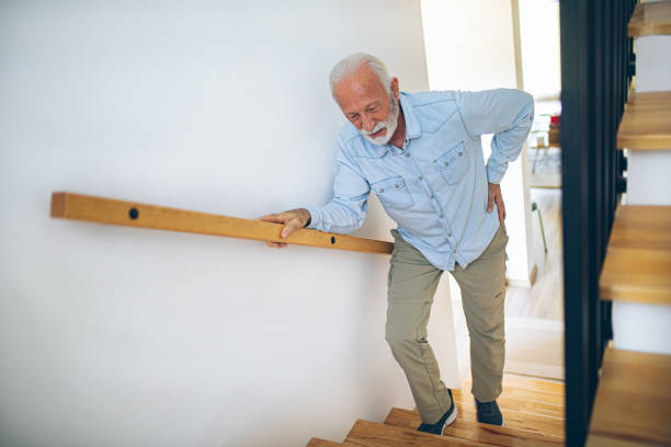 senior man climbs the stairs with difficulty - pijn fotos stockfoto's en -beelden