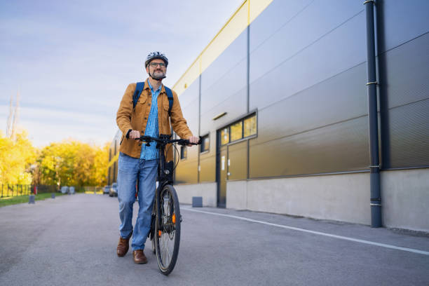 istock Mid-adult Caucasian man pushing the bicycle, while commuting to the work 2180931808